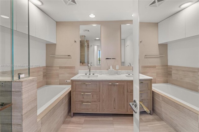 bathroom featuring tile patterned floors, vanity, and shower with separate bathtub