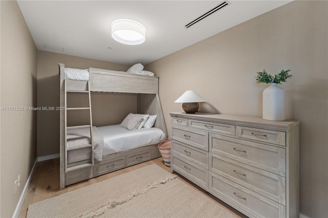 bedroom featuring light wood-style floors, baseboards, and visible vents