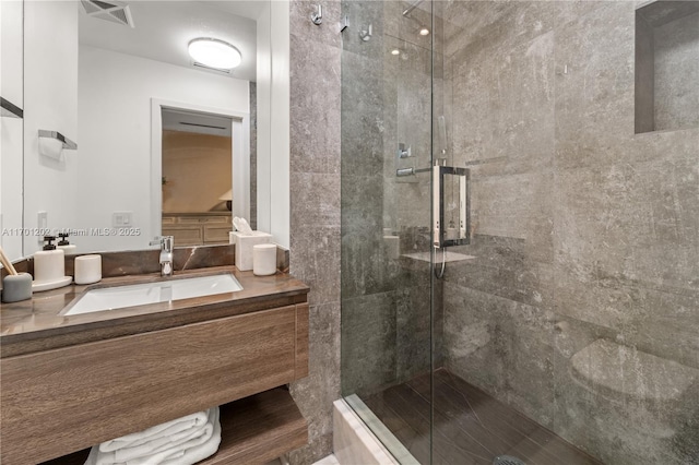 full bath featuring visible vents, a shower stall, and vanity