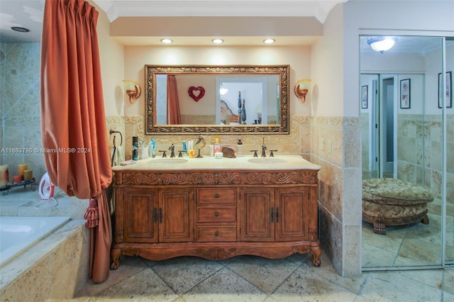 bathroom with tiled tub, vanity, tile walls, and ornamental molding