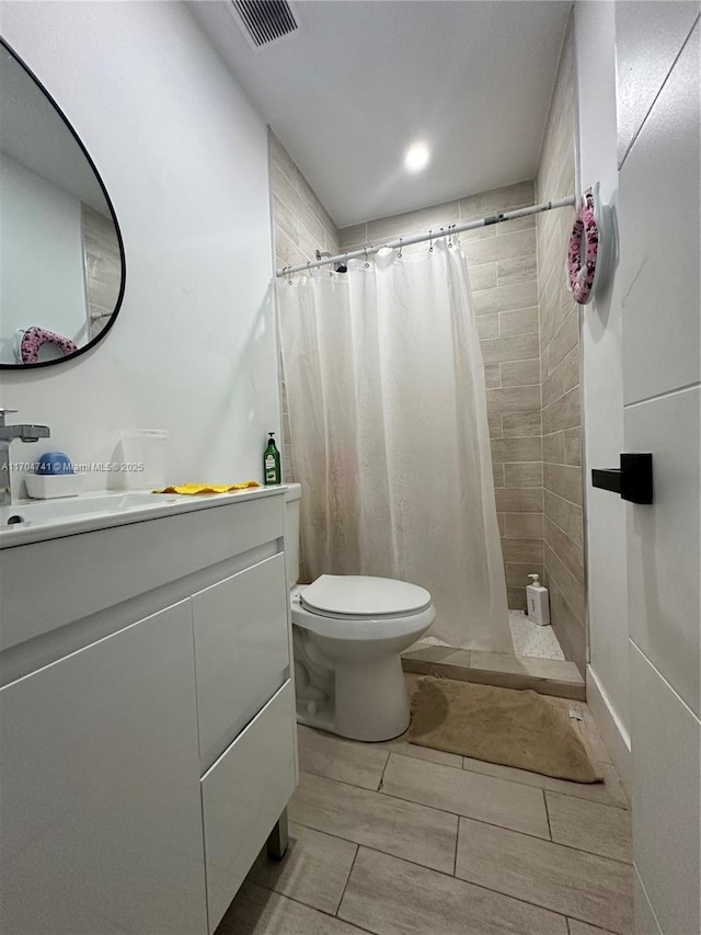 bathroom with vanity, toilet, and walk in shower