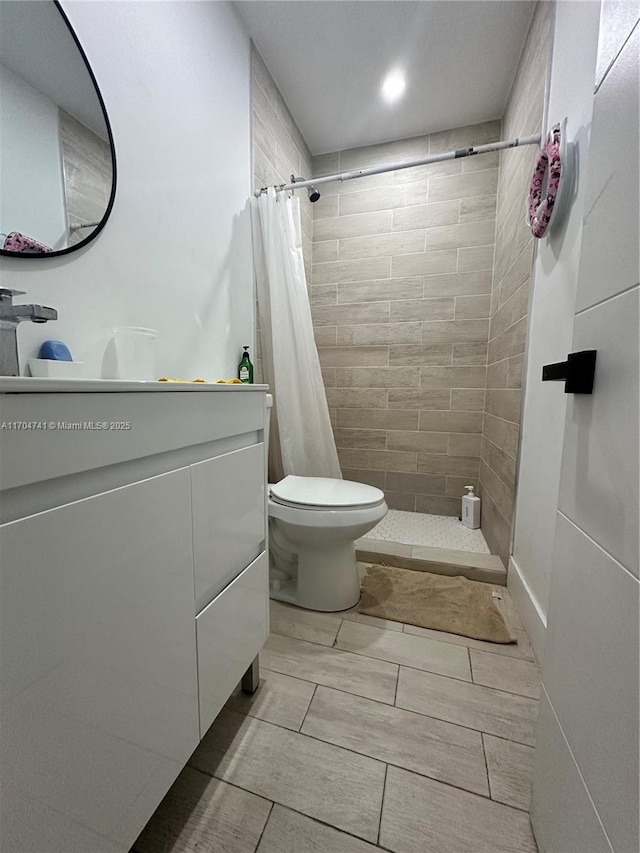 bathroom featuring toilet, vanity, and a shower with shower curtain