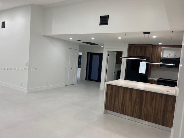 kitchen with washer / clothes dryer, dark brown cabinets, and pendant lighting