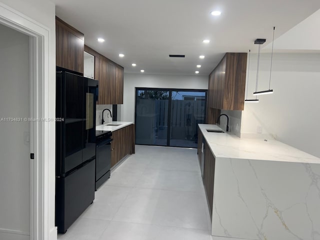 kitchen featuring black appliances, decorative light fixtures, light stone countertops, and sink