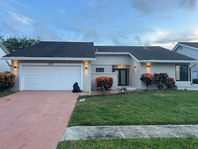 view of front of house featuring a garage and a front lawn