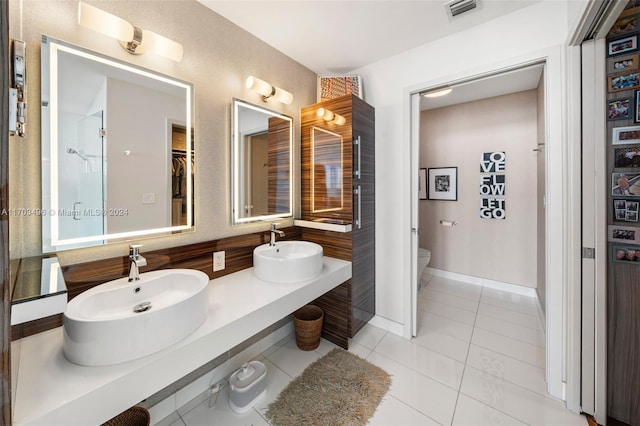 bathroom featuring toilet, vanity, and tile patterned floors