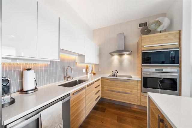 kitchen with wall chimney range hood, sink, black appliances, dark hardwood / wood-style floors, and white cabinetry