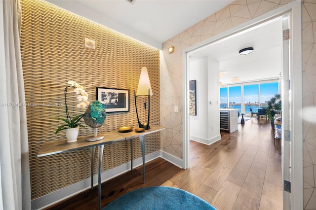 corridor featuring hardwood / wood-style flooring, floor to ceiling windows, and a water view