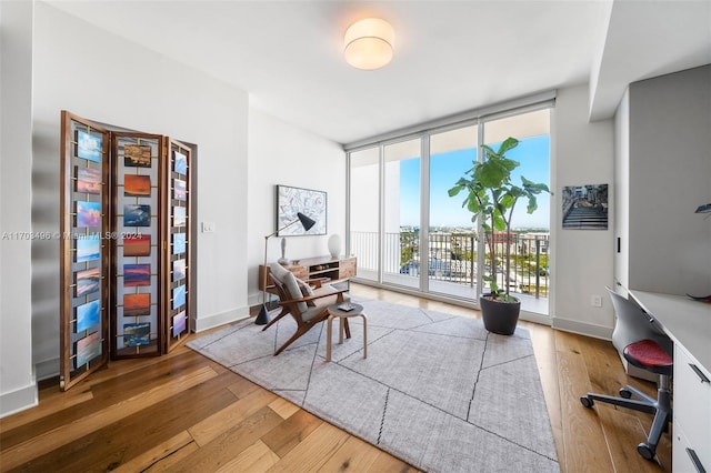 office space with floor to ceiling windows and wood-type flooring