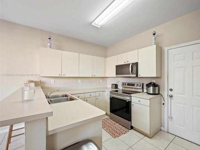 kitchen featuring kitchen peninsula, a breakfast bar, stainless steel appliances, sink, and light tile patterned floors