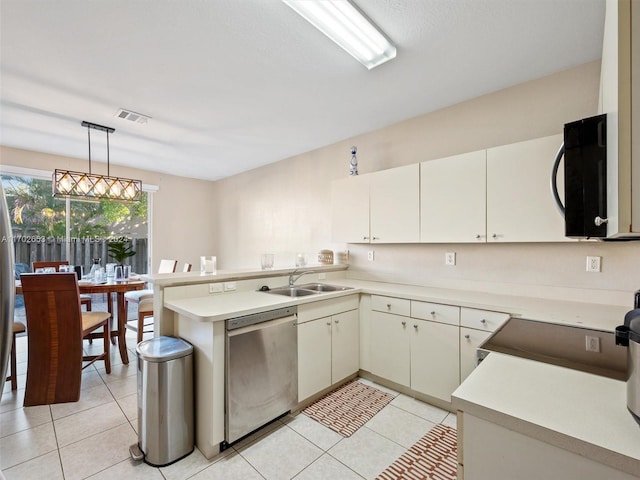 kitchen featuring pendant lighting, dishwasher, sink, light tile patterned floors, and kitchen peninsula