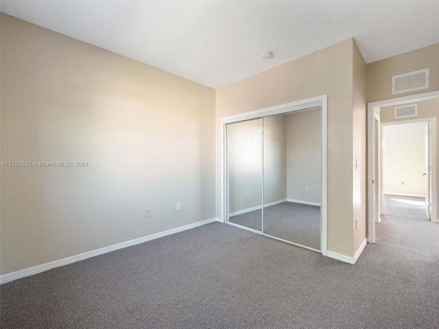 unfurnished bedroom with a closet and carpet