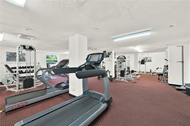 workout area with carpet floors and a textured ceiling