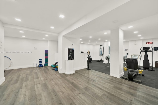 workout area with light hardwood / wood-style flooring