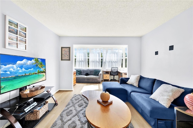 living room with a textured ceiling and light wood-type flooring