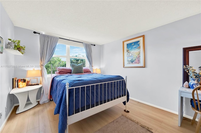 bedroom with a textured ceiling and hardwood / wood-style flooring