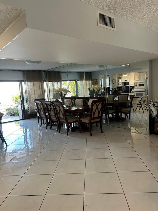 tiled dining area featuring a textured ceiling