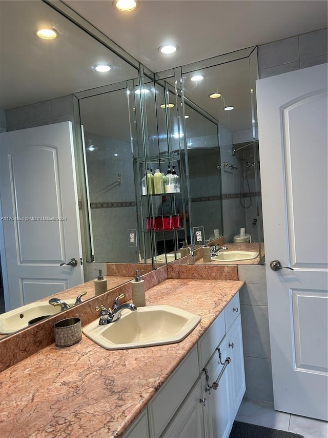 bathroom featuring tile patterned flooring, vanity, and an enclosed shower