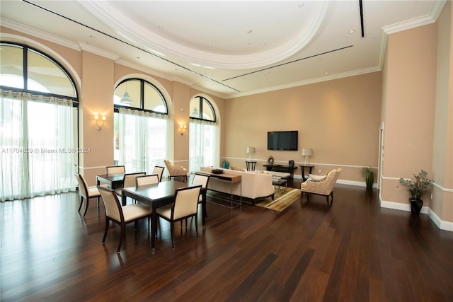 dining space featuring dark hardwood / wood-style flooring, a tray ceiling, and crown molding