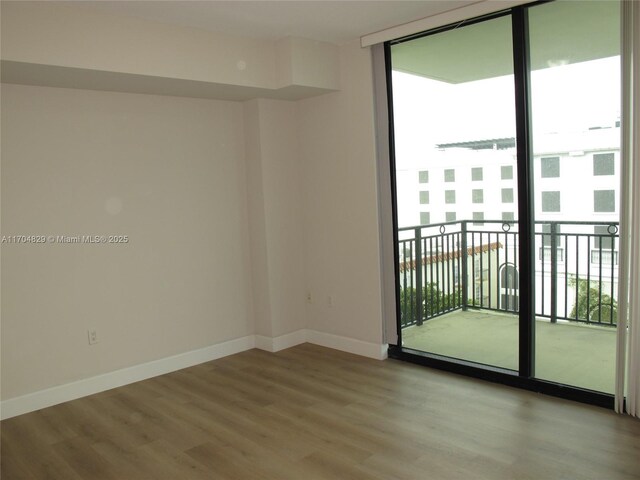 empty room with light hardwood / wood-style floors and floor to ceiling windows