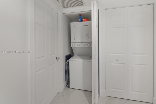 clothes washing area with stacked washer and clothes dryer