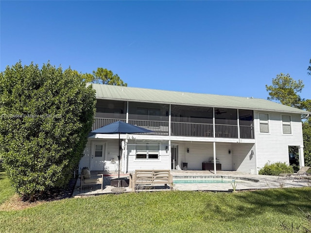 back of property featuring a sunroom, a yard, and a patio area