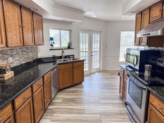 kitchen featuring french doors, sink, dark stone counters, stainless steel appliances, and backsplash