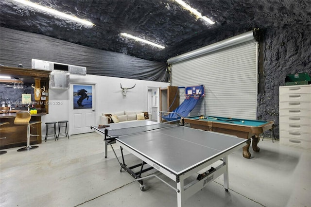 game room with concrete flooring and bar area