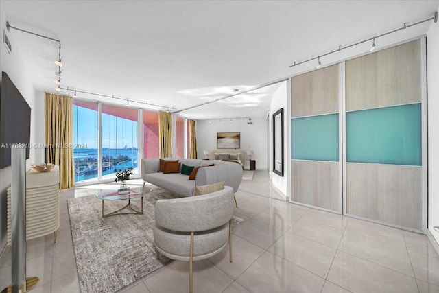 tiled living room featuring track lighting and a water view