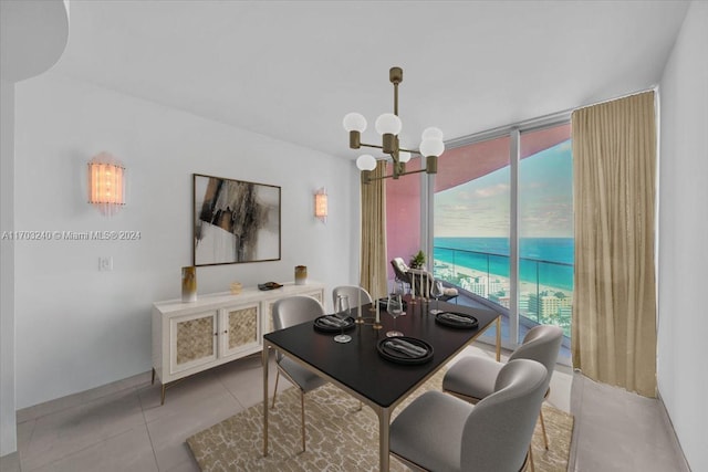 tiled dining area featuring plenty of natural light, a water view, and a notable chandelier