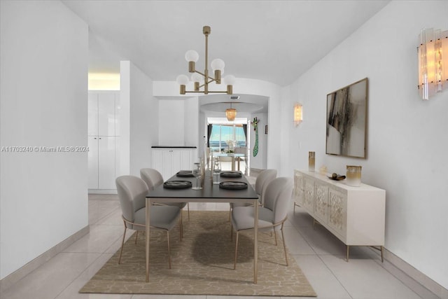 dining room featuring light tile patterned flooring and an inviting chandelier