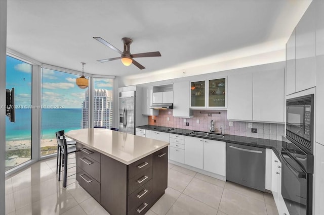 kitchen featuring white cabinets, sink, a water view, and black appliances