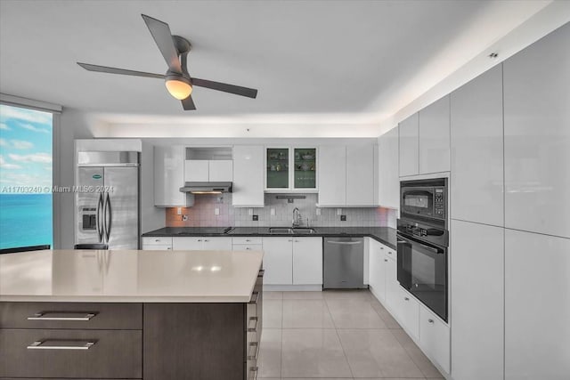 kitchen featuring black appliances, a center island, white cabinetry, and sink