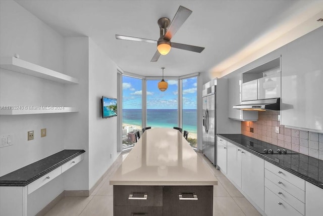 kitchen featuring a center island, white cabinetry, plenty of natural light, and range hood