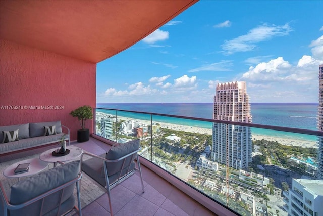 balcony with outdoor lounge area, a water view, and a view of the beach