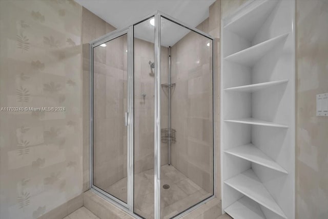 bathroom featuring a shower with shower door