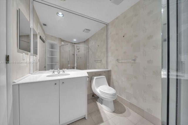 bathroom featuring tile patterned floors, vanity, toilet, and walk in shower