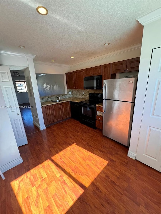 kitchen with sink, dark wood-type flooring, crown molding, decorative backsplash, and black appliances