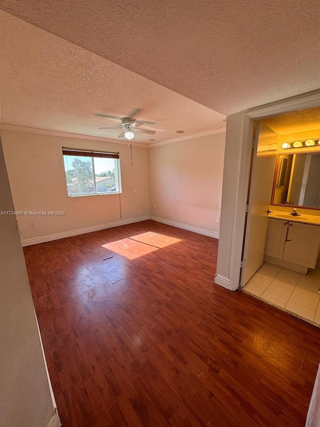 empty room featuring ceiling fan, ornamental molding, a textured ceiling, and light hardwood / wood-style flooring