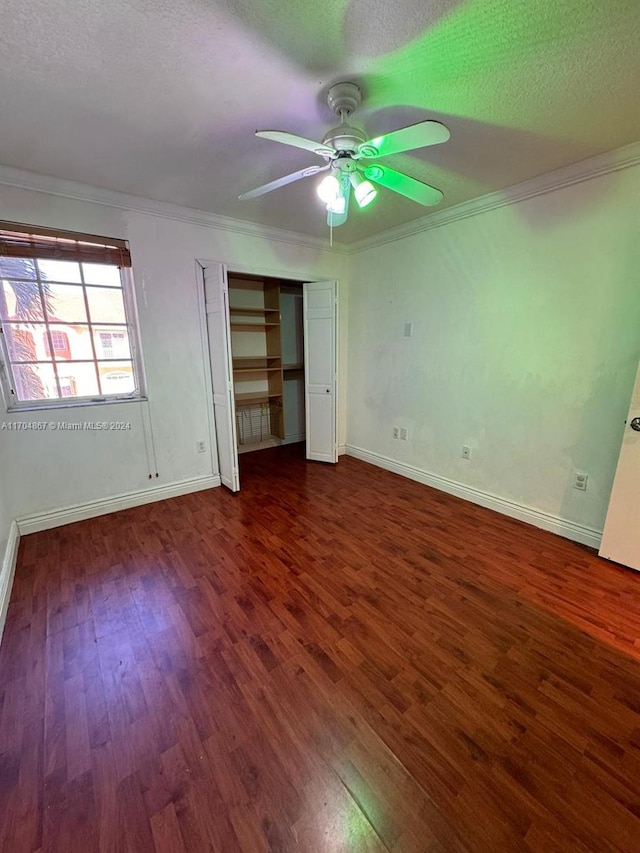 unfurnished bedroom featuring ceiling fan, crown molding, and dark wood-type flooring