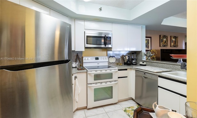 kitchen with white cabinetry, light tile patterned floors, and appliances with stainless steel finishes