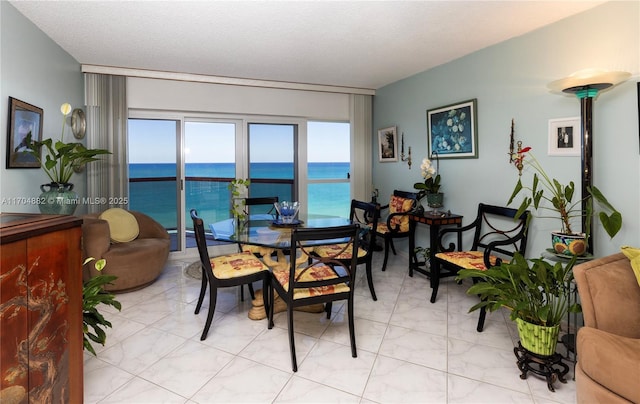 dining area with a textured ceiling and a water view