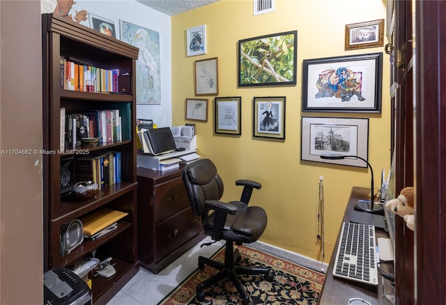 tiled office space featuring a textured ceiling