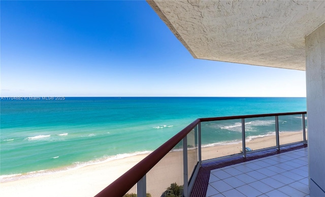 balcony featuring a beach view and a water view