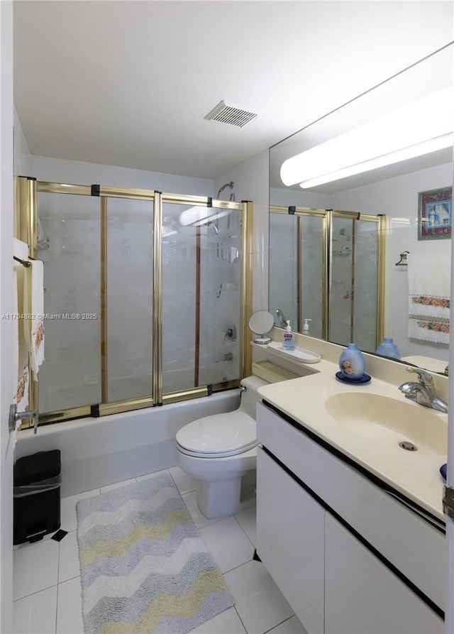 full bathroom with toilet, vanity, tile patterned floors, and bath / shower combo with glass door