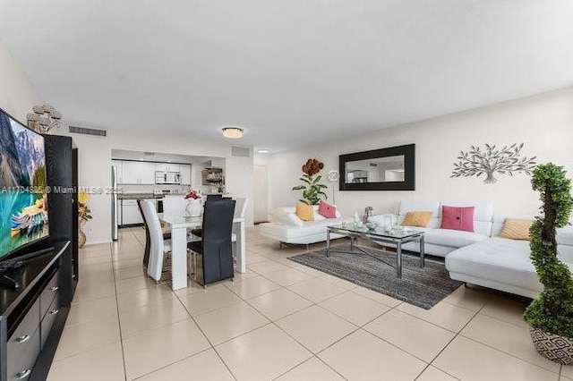 living area featuring visible vents and light tile patterned flooring