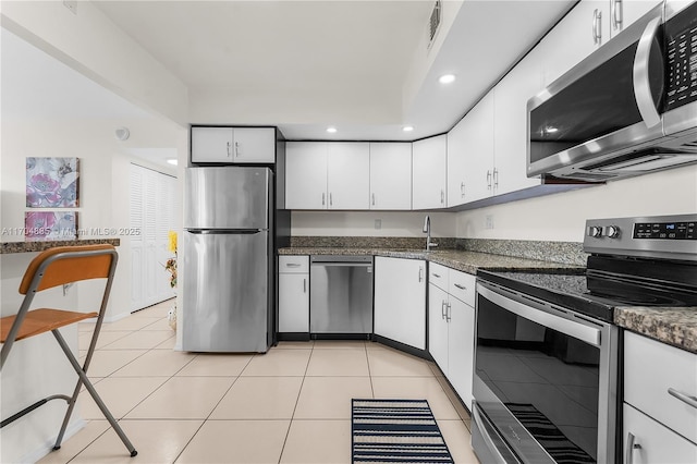 kitchen with a sink, stainless steel appliances, white cabinetry, and visible vents