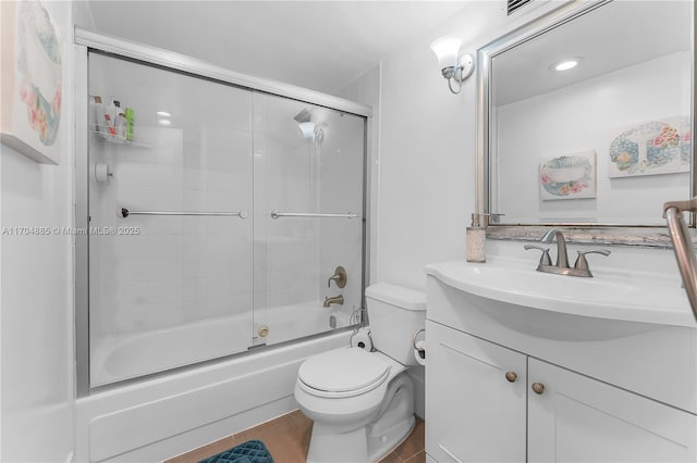 bathroom featuring toilet, enclosed tub / shower combo, wood finished floors, and vanity