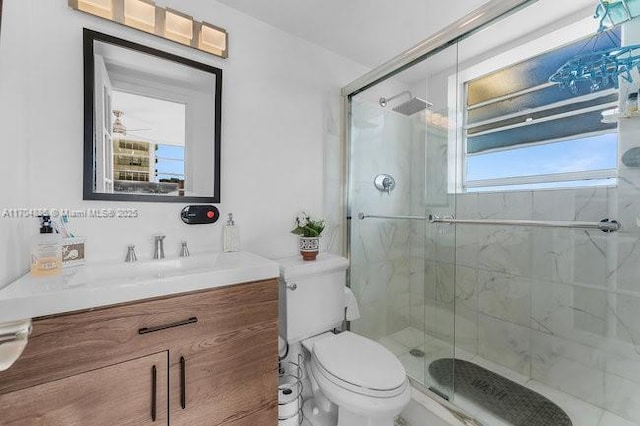 full bathroom featuring a stall shower, vanity, and toilet