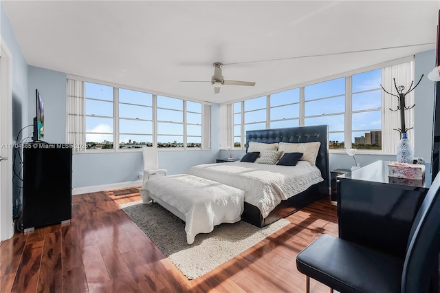 bedroom featuring baseboards, ceiling fan, and dark wood finished floors